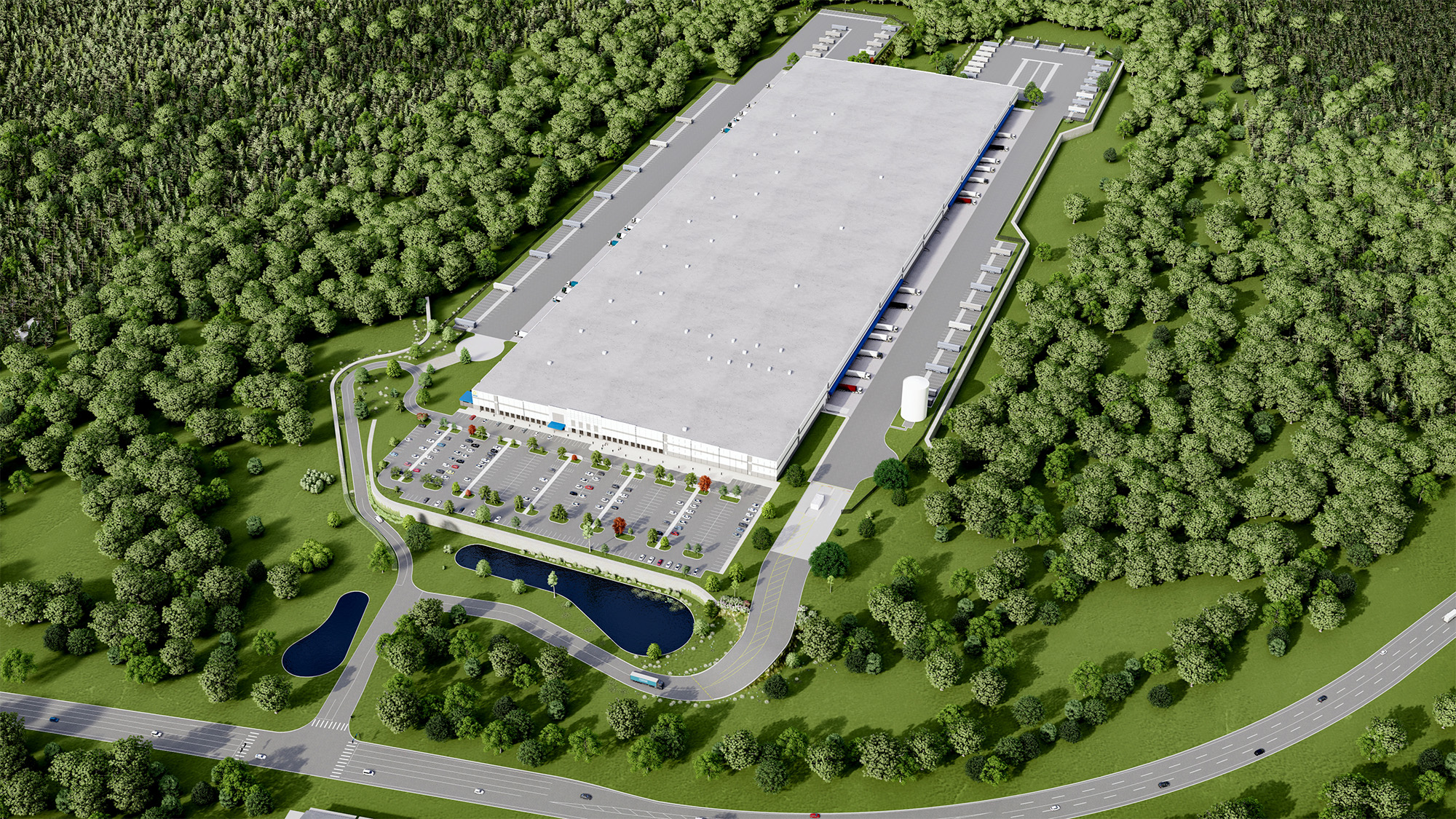 Aerial view of a large industrial building surrounded by a lush forest. The building has multiple loading docks with trucks parked. A parking lot with cars is in front, and there are small ponds and roads around the area.